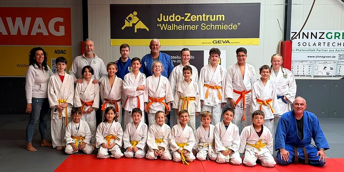 Gruppenfoto der Kinder in Judoanzügen mit Trainerinnen und Trainern vor dem Banner „Judo-Zentrum Walheimer Schmiede“ beim Judo-Camp in Walheim.